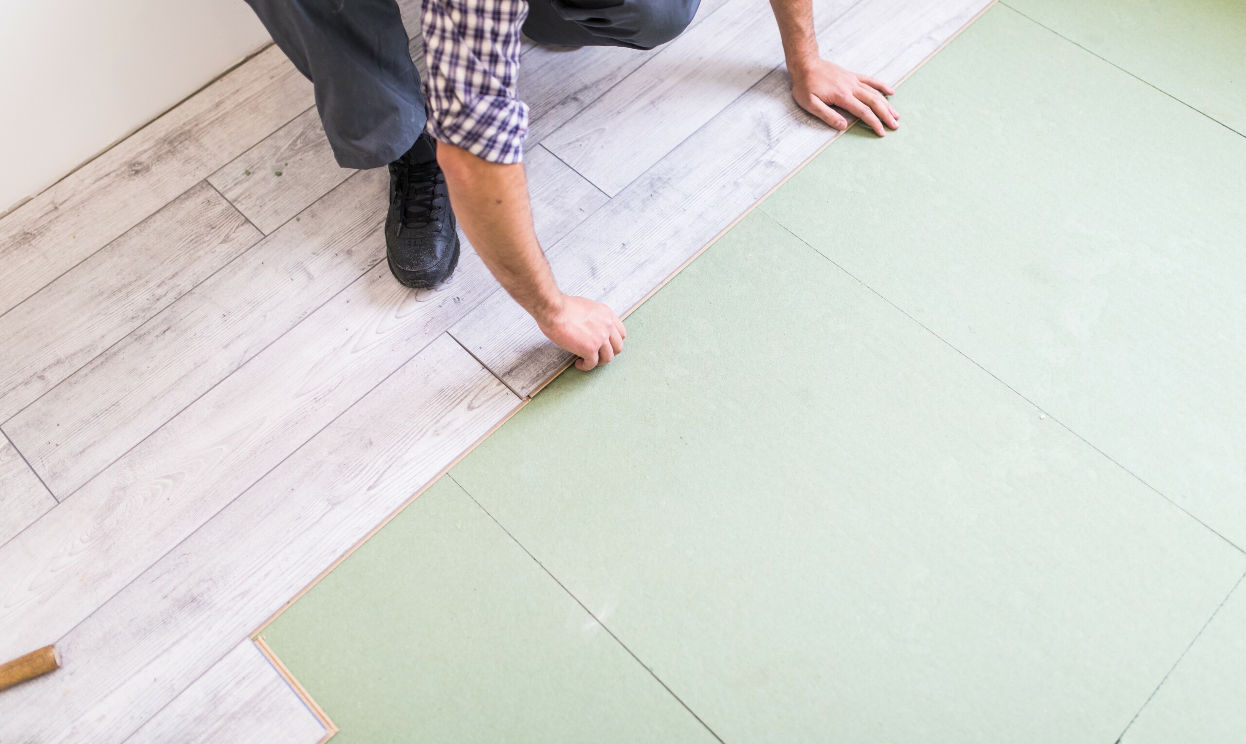Worker Processing A Floor With Bright Laminated Flooring Boards